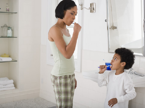 mother and child brushing teeth together