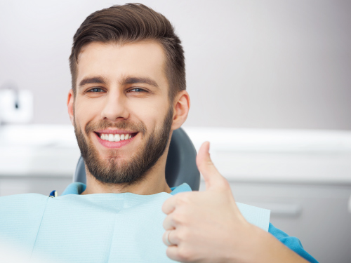 man in dental chair giving thumbs up no dental anxiety