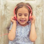 young girl listening to a song through headphones