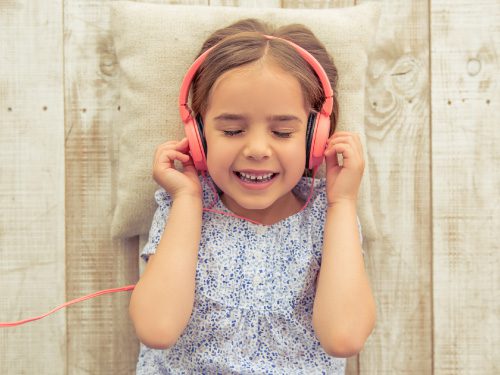 young girl listening to a song through headphones