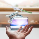 Person's hand tossing a whiteing tray and syringe with whitening gel into the air in front of a tv screen.