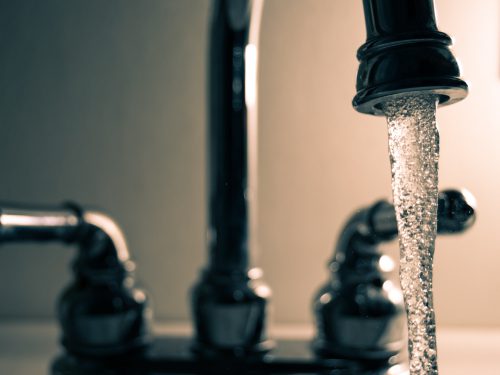 A stream of water runs from a stainless steel faucet