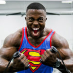 bodybuilder in superman shirt showing off his pearly white teeth