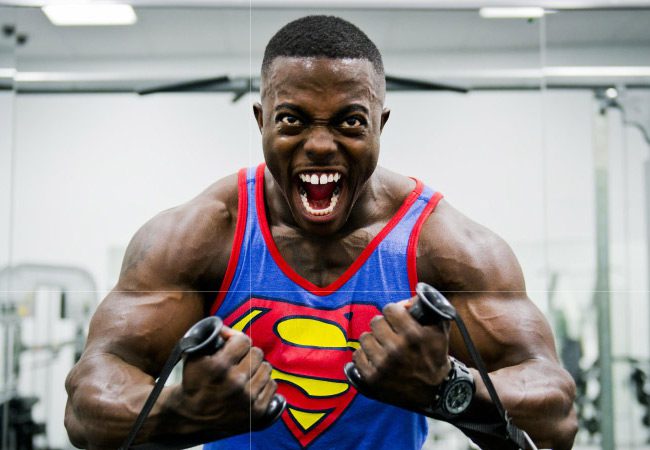 bodybuilder in superman shirt showing off his pearly white teeth